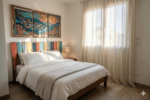 Chambre lumineuse avec tête de lit aux motifs nautiques et œuvres océanes à la villa Chez Domi à Canet-en-Roussillon