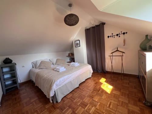Chambre lumineuse du gîte Le Petit Poisson Rouge à Destination Etretat avec lit, parquet, suspension et jardin