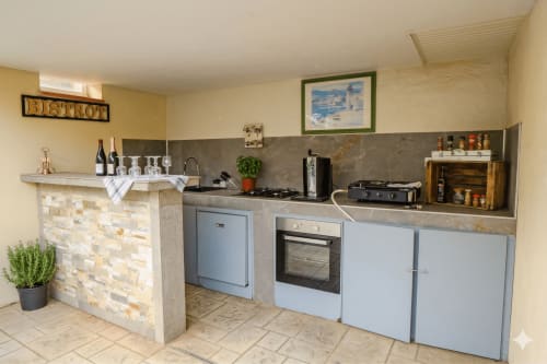 Cuisine contemporaine de villa avec armoires bleues, crédence en pierre et électroménagers inox chez Chez Domi à Canet-en-Roussillon
