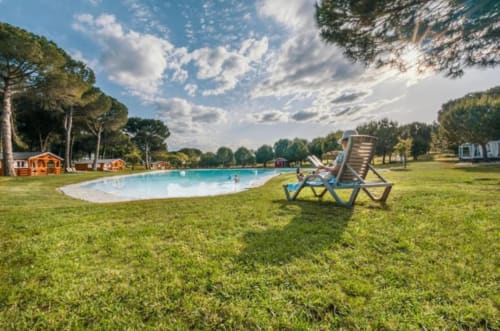 Relaxing poolside at Chalet Do Lago, Montargil - lounge chair overlooking the lake pool and green lawns