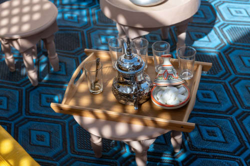 Service de thé marocain au Riad Dabachi Tala'lou à Marrakech avec théière traditionnelle, verres et sucrier sur motifs géométriques bleus