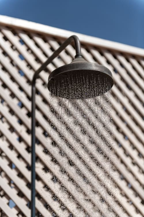 Pommeau de douche noir avec eau jaillissante sur mur à motifs au Riad Dabachi Tala'lou, Marrakech