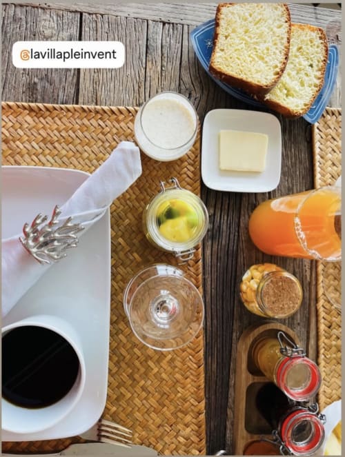 Frühstückstisch in der La Villa Plein Vent mit Toast, Butter, Saft, Kaffee und Aufstrichen auf rustikalem Tisch.