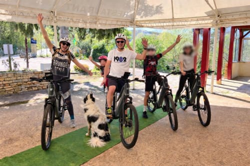 Groupe de cyclistes avec un chien célébrant à la Maison Lapopie, gîte accueillant les vélos à Saint-Cirq-Lapopie, France