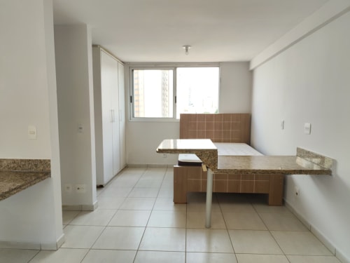 Cozinha vazia com bancadas de granito e azulejaria marrom no hotel Wellington Rodovalho em Goiânia