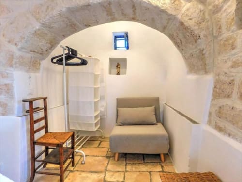Appartamento Ada Trullo a Pietra & Luce di Ostuni con muri in pietra imbiancata, soffitto ad arco, letto e arredi rustici