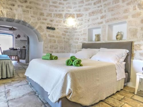 Camera da letto in pietra con soffitto ad arco nell'appartamento Ada Trullo, Pietra & Luce, Ostuni, Italia