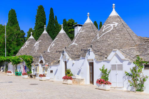 Case trulli di Pietra & Luce a Ostuni, Italia con muri imbiancati, tetti conici e fiori colorati
