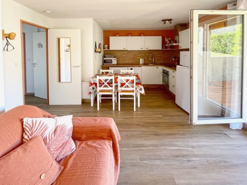 Cuisine ouverte et séjour de l'Appartement 117 au Vallon des Sources à Digne-les-Bains, avec table à manger et jardin