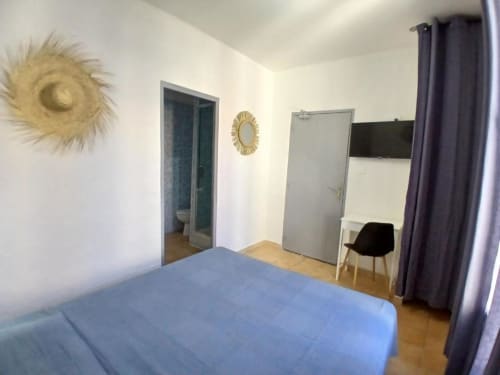 Comfortable double room at Hôtel Quai d'Azur with bed, TV, desk, and en-suite bathroom in Le Grau-du-Roi