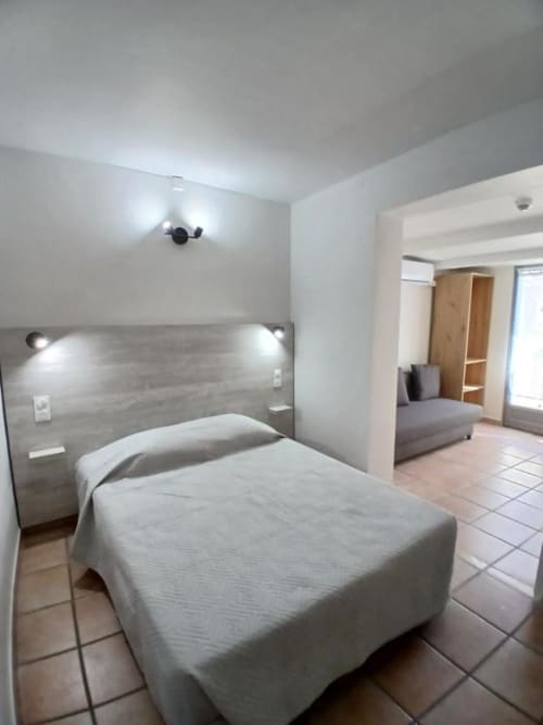 Superior double room at Hôtel Quai d'Azur in Le Grau-du-Roi with bed, modern headboard, and living area