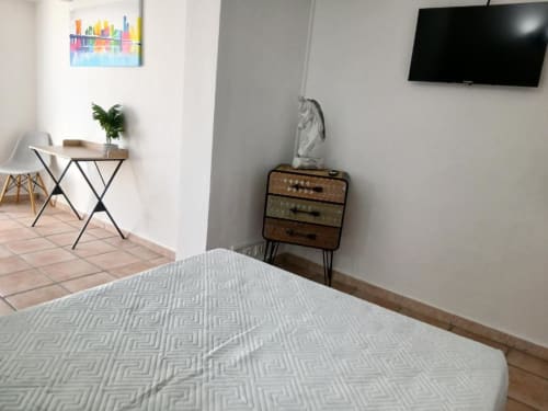 Superior double room at Hôtel Quai d'Azur in Le Grau-du-Roi with bed, desk, TV, and vintage dresser