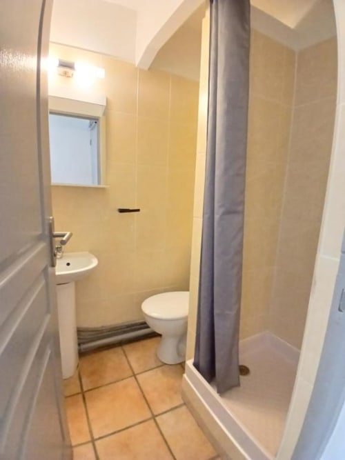 Bathroom at Hôtel Quai d'Azur in Le Grau-du-Roi with toilet, sink, shower and yellow tiled walls