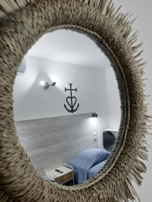 Rope-framed mirror reflecting coastal room at Hôtel Quai d'Azur in Le Grau-du-Roi, France