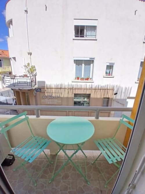 Turquoise bistro set on balcony at Hôtel Quai d'Azur in Le Grau-du-Roi with coastal street view