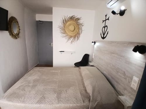 Classic double bedroom at Hôtel Quai d'Azur in Le Grau-du-Roi with bed, coastal décor, and modern amenities