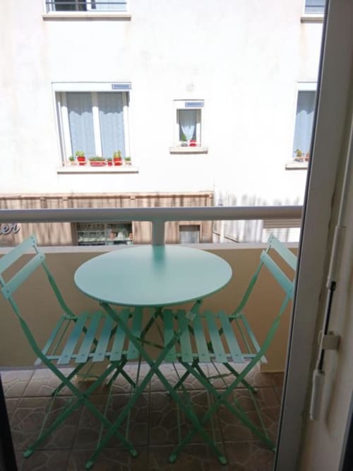 Turquoise bistro table and chairs on a balcony at Hôtel Quai d'Azur, Le Grau-du-Roi