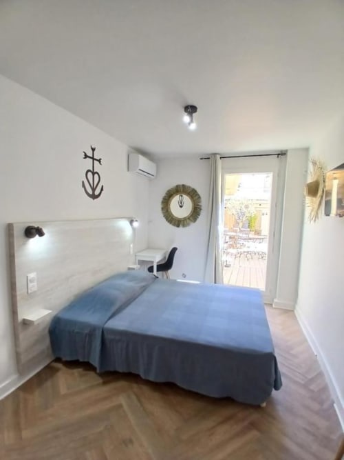 Hôtel Quai d'Azur double room with blue bed, balcony access, and modern decor in Le Grau-du-Roi