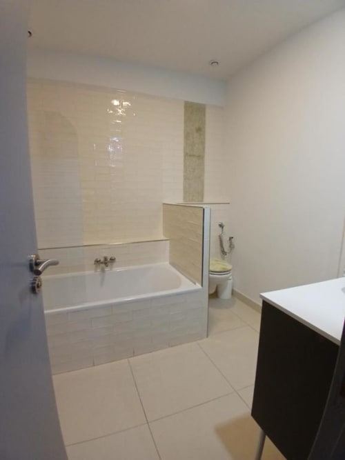 Modern bathroom with white bathtub, glass shower screen, and tile flooring at Hôtel Quai d'Azur, Le Grau-du-Roi