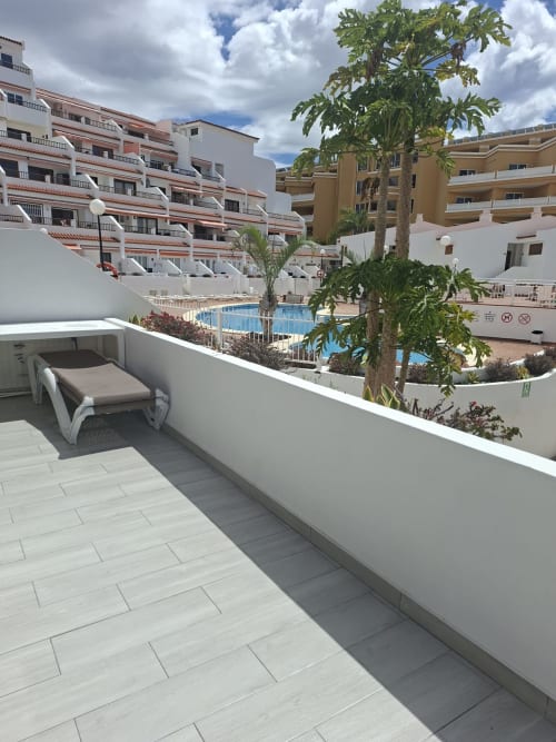 Private balcony with lounge chair overlooking pool at Costa Adeje apartment