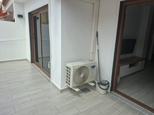 Modern apartment entryway in Costa Adeje with air conditioning unit, tiled flooring, and access to balcony and living areas