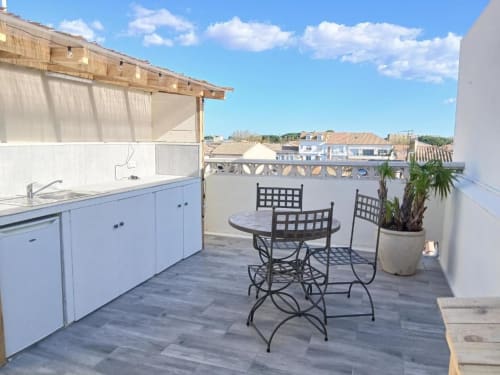 Rooftop terrace at Hôtel Quai d'Azur with dining area, kitchenette, and sea views in Le Grau-du-Roi