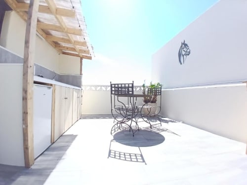 Rooftop terrace at Hôtel Quai d'Azur with metal furniture and horse mural, Le Grau-du-Roi