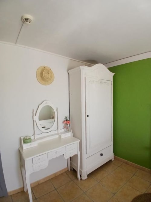 Modern bedroom with white vanity, round mirror, and wardrobe at Hôtel Quai d'Azur in Le Grau-du-Roi