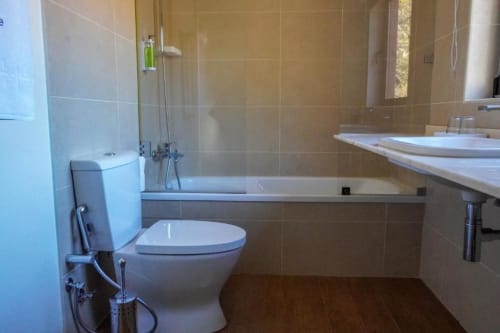 Banheiro moderno na Suíte Deluxe da Quinta de Anterronde com WC, banheira, pia e paredes revestidas