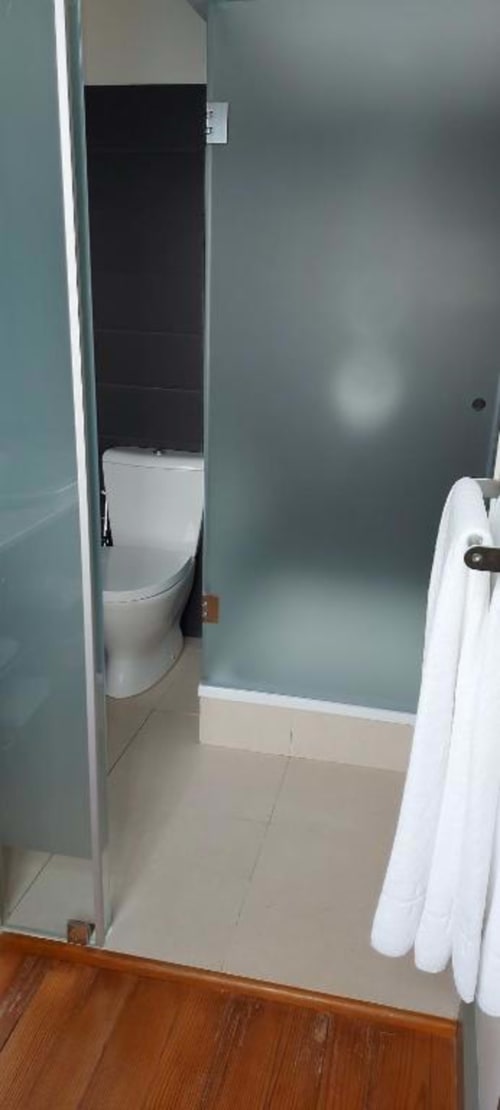 Casa de banho moderna na Quinta de Anterronde com sanita branca, paredes azul-turquesa e pavimento em ladrilho creme no Quarto Duplo Standard