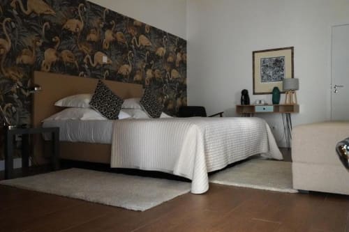 Quarto moderno da Quinta de Anderronde em Arouca com papel de parede botânico, cama bege, almofadas estampadas e vista para o jardim