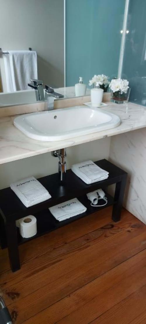 Lavatório de banheiro com bancada de mármore na Quinta de Anterronde B&B em Arouca, Portugal, com parede de destaque turquesa