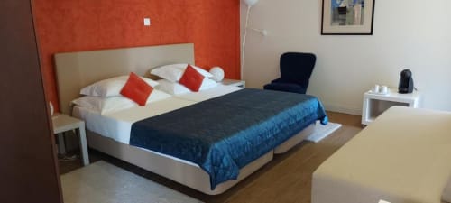 Quarto familiar da Quinta de Anterronde com cama de casal, detalhes em vermelho e comodidades modernas em Arouca, Portugal