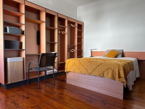 Modern bedroom at Golden Mermaid Villa with double bed, yellow bedding, wooden shelving, desk area, and hardwood floors