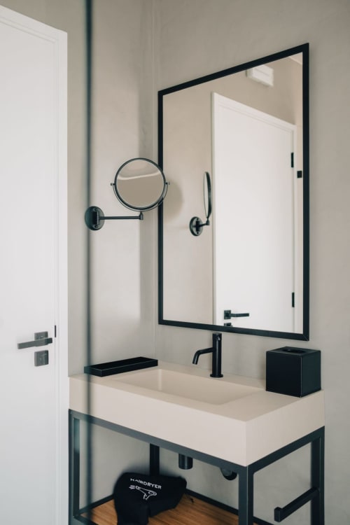 Banheiro moderno do hotel M'ar Puro com espelho com moldura preta, cuba de porcelana e espelho de parede para cosméticos