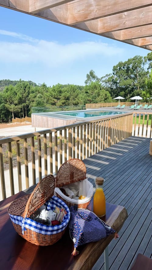 Cesta de piquenique em deck de madeira com vista para a piscina em M'ar Puro, Santo Isidoro com vistas da floresta