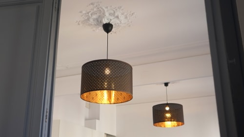 Iluminación colgante moderna con interior dorado en sala de estar de apartamento Barcelona Eixample
