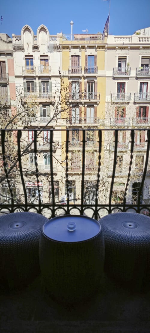 Vista desde el balcón del colorido edificio residencial de Barcelona en Eixample con skyline y barandilla de hierro forjado