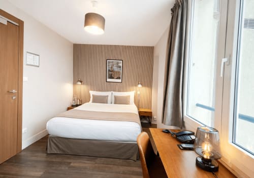 Chambre confortable à l'Hôtel Des Cèdres à Orléans avec lit queen-size, bureau de travail et vue sur la ville
