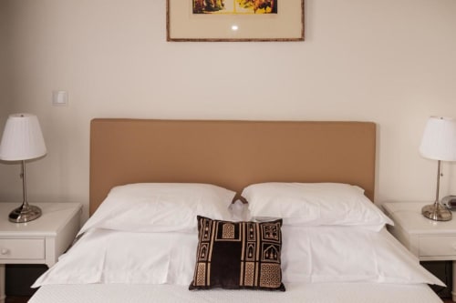 Quarto de casal elegante na Quinta de Anterronde com cabeceira bege, roupa de cama branca, luminárias laterais e vistas para a montanha