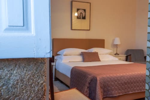 Quarto de casal aconchegante na Quinta de Anterronde com vista para a montanha, piso em madeira, roupa de cama branca e decoração quente