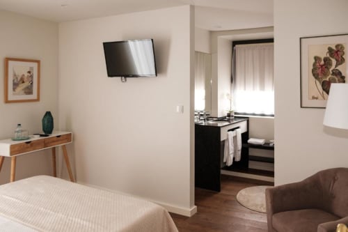 Quarto Standard da Quinta de Anterronde com TV, secretária, acesso a casa de banho e vista para o jardim em Portugal