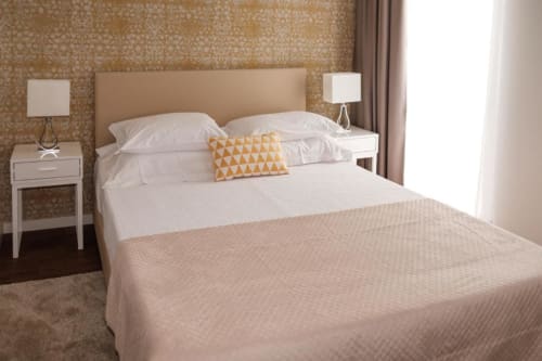 Suite Standard iluminada na Quinta de Anterronde com vista para o jardim, cama em tons creme e almofada amarela