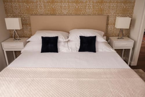 Suite de quarto moderno em Quinta de Anterronde com roupa de cama branca, almofadas de acentuação preta, mesas laterais em par com lâmpadas, e