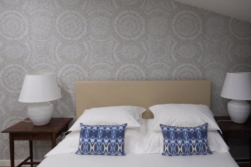 Quarto Suite Standard da Quinta de Anterronde com cabeceira bege, roupa de cama branca, almofadas estampadas azuis e padrões decorativos