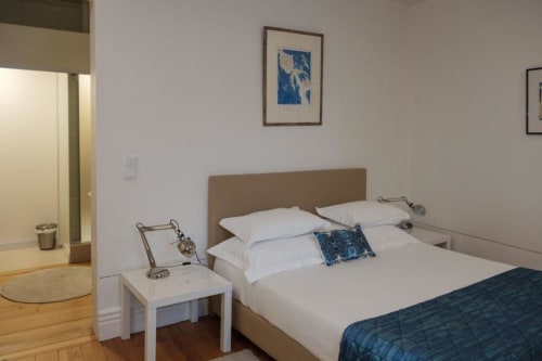 Quarto espaçoso na Quinta de Anterronde com cama queen, roupa de cama branca, detalhes em azul, secretária e comodidades modernas
