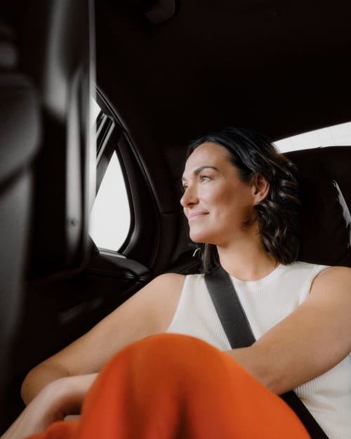 Femme en débardeur blanc assise dans une voiture à l'hôtel Vista Del Mar, Sainte-Anne, Guadeloupe
