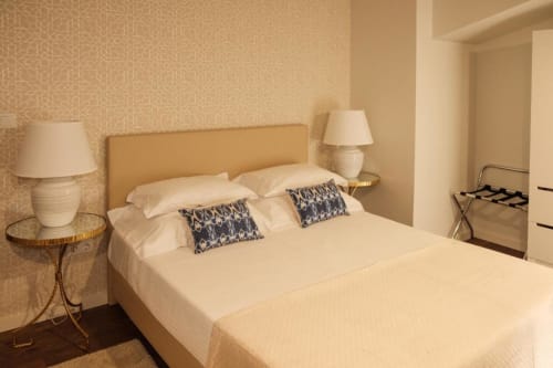 Quarto Triplo Superior da Quinta de Anterronde com cama de roupa creme, almofadas estampadas, luminárias de cabeceira e padrão bege