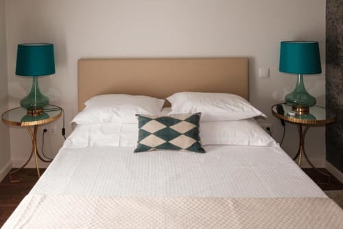 Quarto elegante da suíte júnior na Quinta de Anterronde com cabeceira bege, roupa de cama branca, luminárias azul-piscina e padrão geométrico