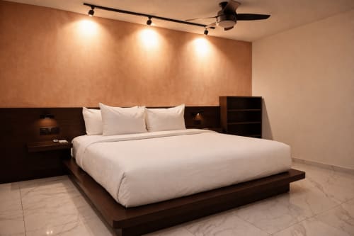 Dormitorio moderno en Villa Merida Boutique Hotel en Mérida con cama king, muebles de madera oscura, iluminación ambiental y mármol